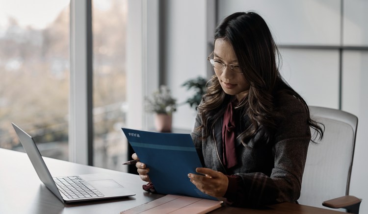 Woman reads FINRA Annual Oversight Report for 2025.